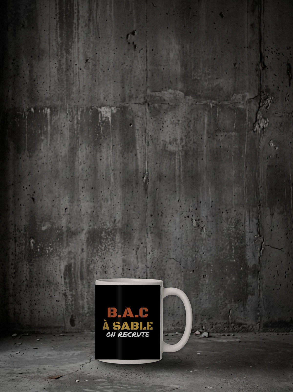Mug B.A.C À Sable posé sur sol béton