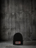Bonnet SURVIVORRR, posé au sol béton